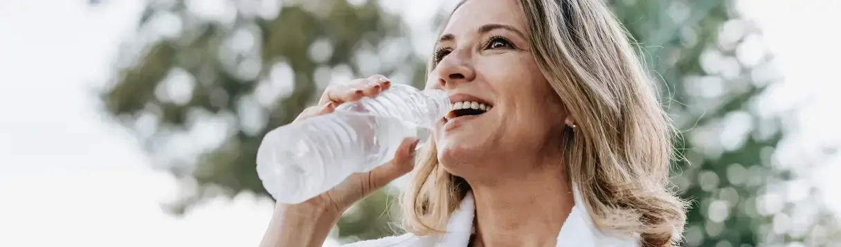 Woman drinking water outdoors